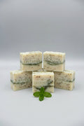 Multiple bars of soap with 'Lea & Haas' branding on a wooden and stone surface.
