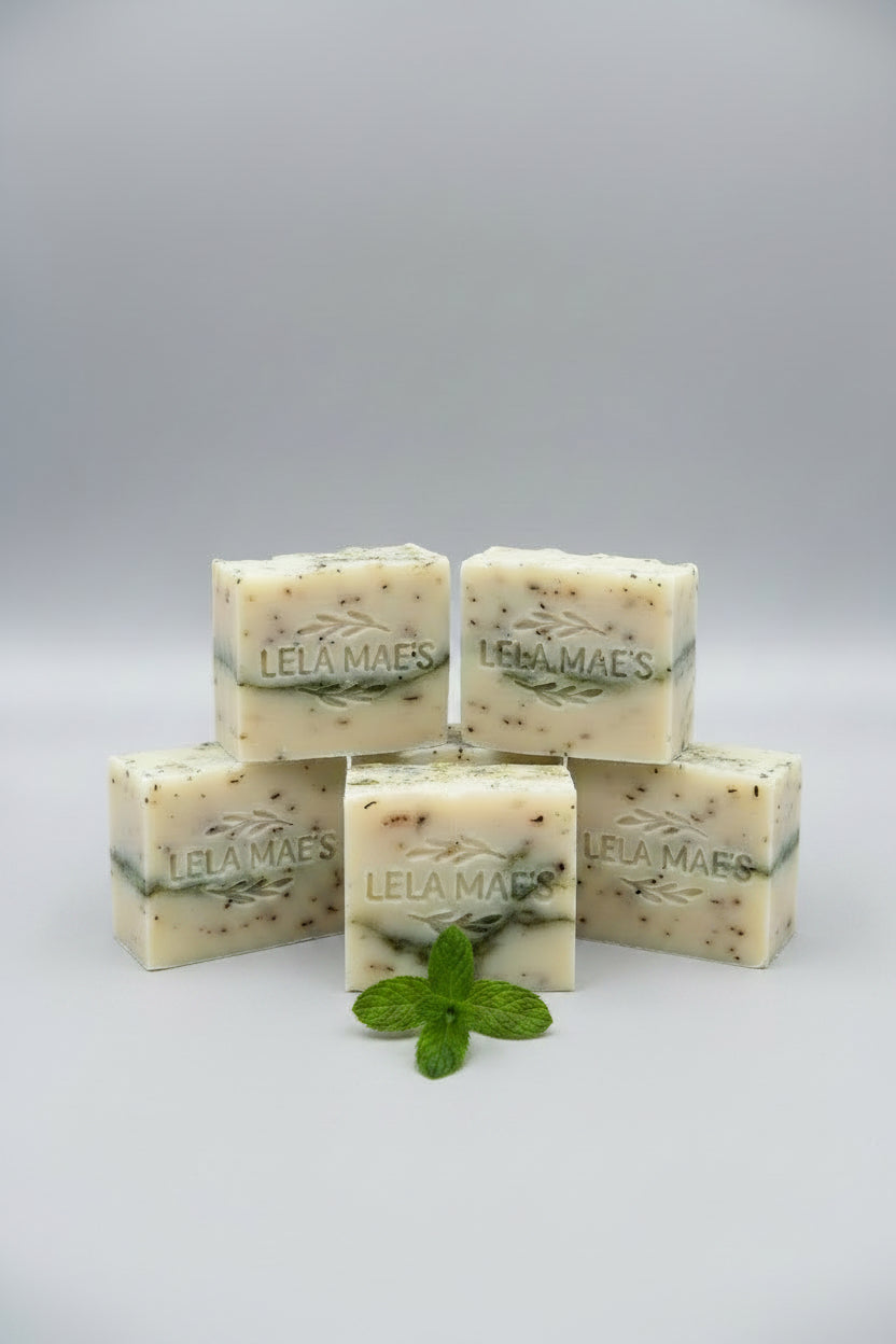 Multiple bars of soap with 'Lea & Haas' branding on a wooden and stone surface.